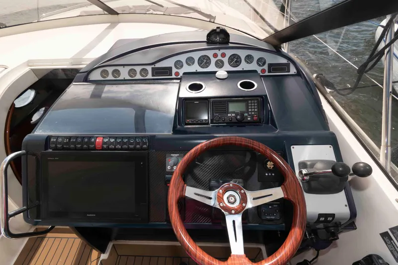 Slide: The Image of 2003 Viking Princess V50 Express helm with wooden steering wheel and navigation controls. - 9