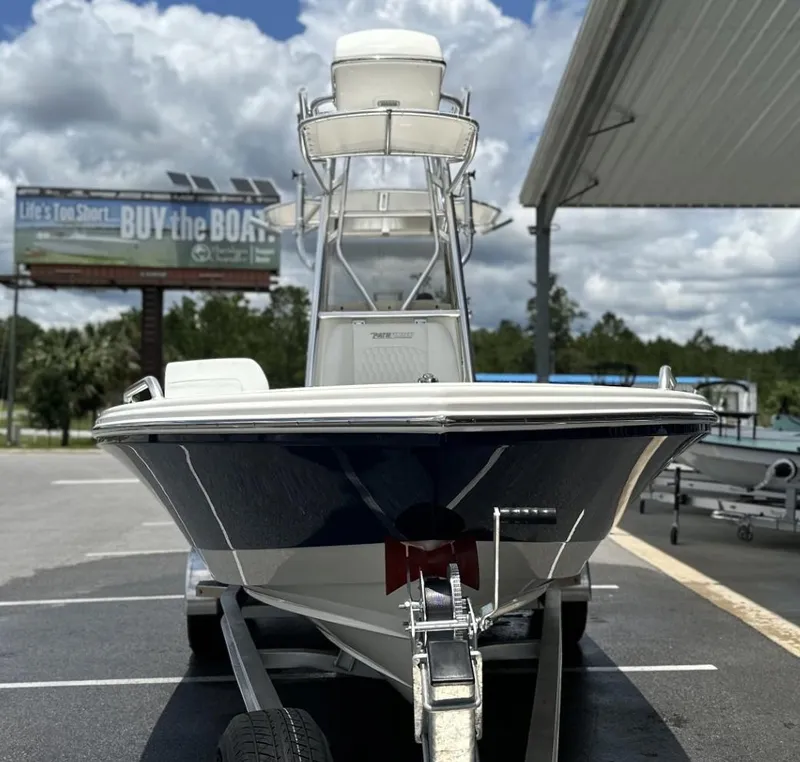 Slide: The Image of 2025 Pathfinder 2600 TRS boat on trailer, under cloudy sky, with billboard in background. - 5