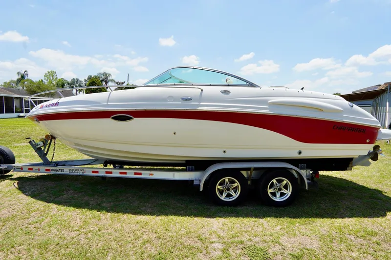 The Image of 2003 Chaparral 225 SSi boat on trailer, white with red accents, parked on grass. - 0