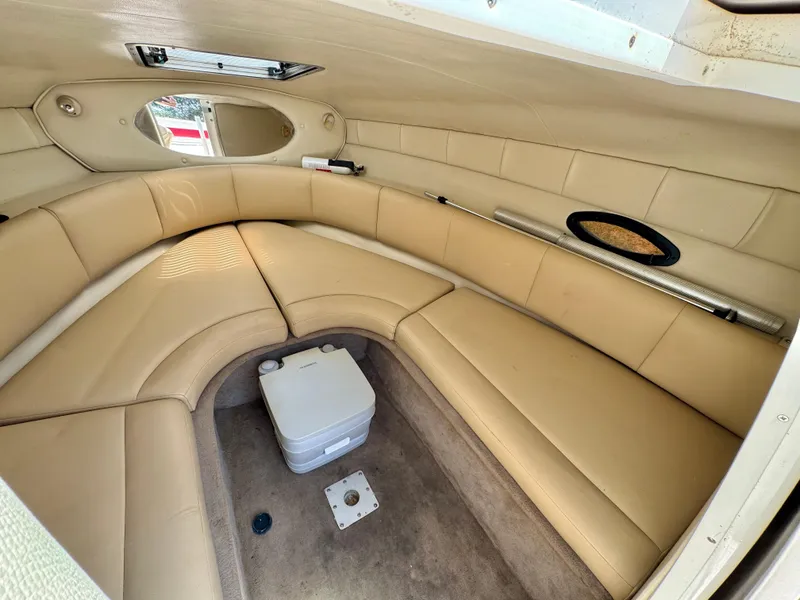Slide: The Image of 2003 Chaparral 225 SSi boat interior with beige seating and a small portable toilet. - 15