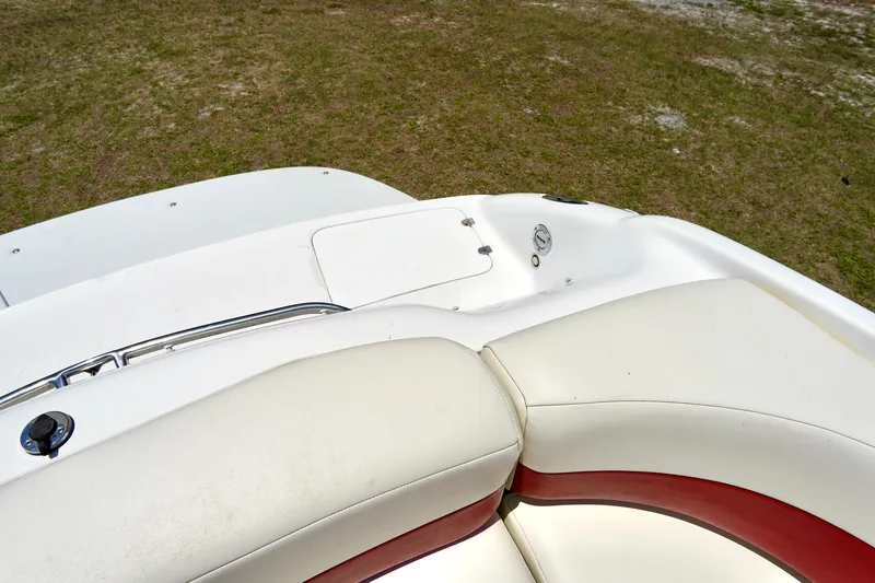 Slide: The Image of 2003 Chaparral 225 SSi boat interior with white and red seating, grassy background. - 23