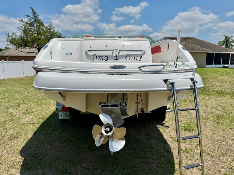 Slide: The Image of 2003 Chaparral 225 SSi boat with ladder and propeller, parked on grass. - 26