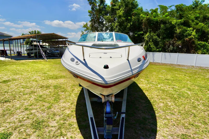 Slide: The Image of 2003 Chaparral 225 SSi boat on trailer, parked on grass under clear sky. - 3