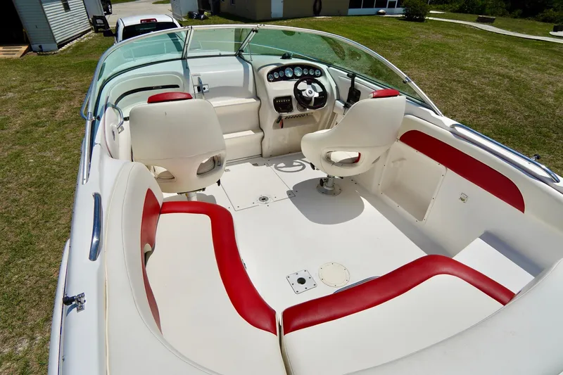 Slide: The Image of 2003 Chaparral 225 SSi boat interior with white and red seating, steering wheel, and dashboard. - 5