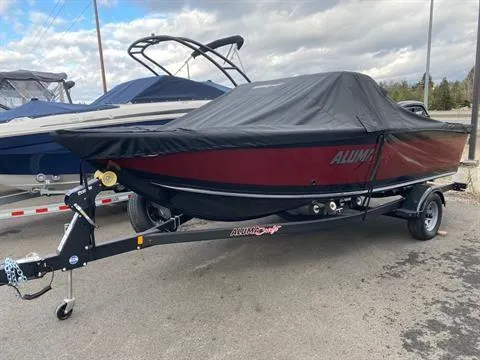 Slide: The Image of 2022 Alumacraft Trophy 185 boat with cover on trailer, parked outdoors. - 11