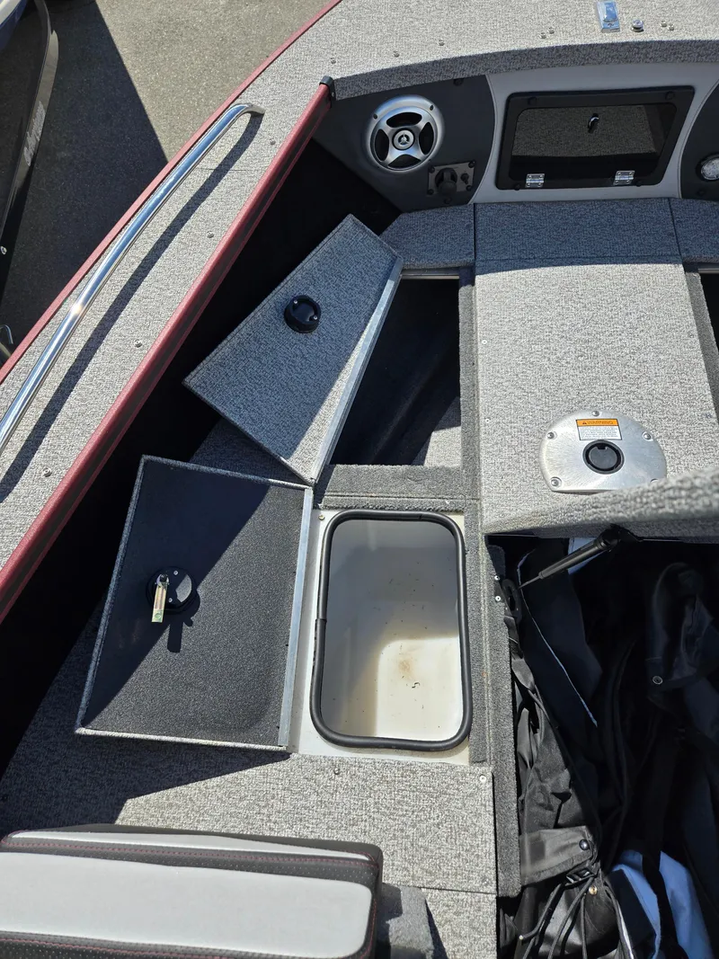 Slide: The Image of 2022 Alumacraft Trophy 185 boat interior with open storage compartments and seating. - 14