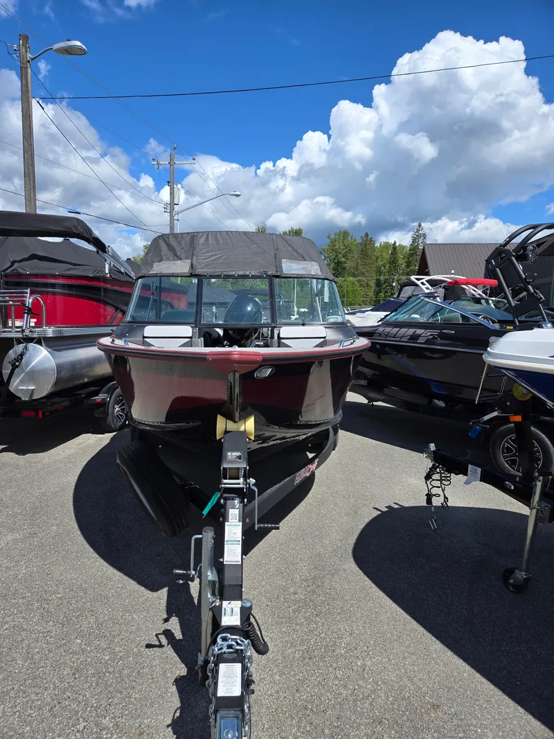 Slide: The Image of 2022 Alumacraft Trophy 185 boat displayed outdoors under a bright blue sky. - 2