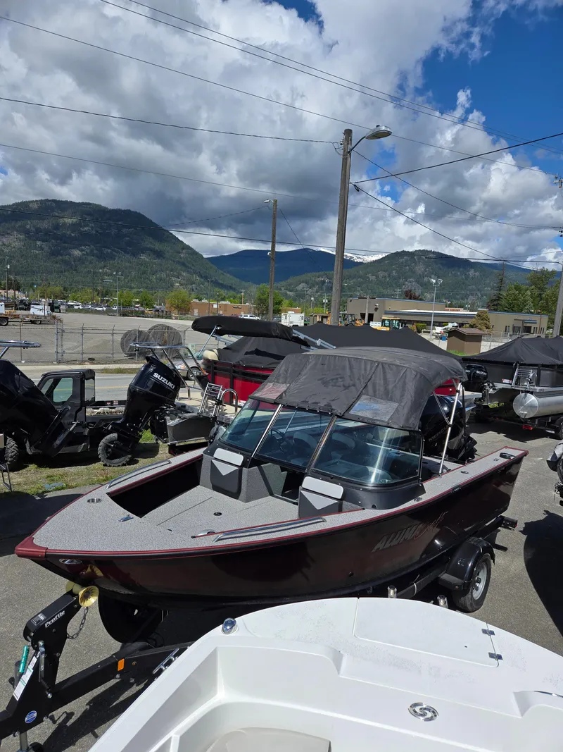 Slide: The Image of 2022 Alumacraft Trophy 185 boat displayed outdoors with scenic mountain backdrop. - 3