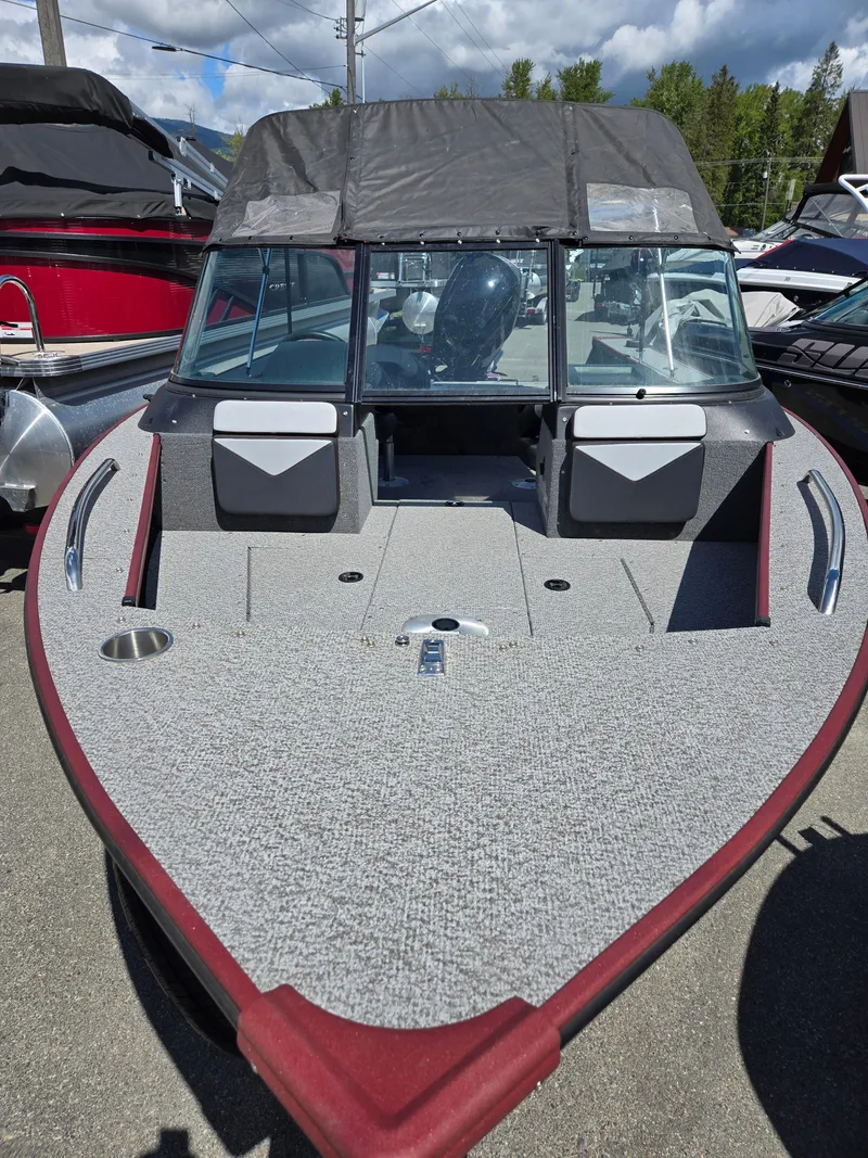 Slide: The Image of 2022 Alumacraft Trophy 185 boat with spacious deck and windshield, parked outdoors. - 5