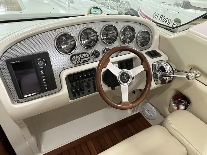 Slide: The Image of 2005 Chris-Craft Corsair 28 dashboard with gauges, steering wheel, and navigation system. - 16