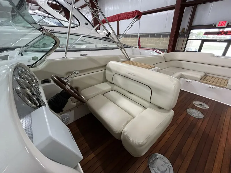 Slide: The Image of 2005 Chris-Craft Corsair 28 interior with white leather seats and wooden flooring. - 18