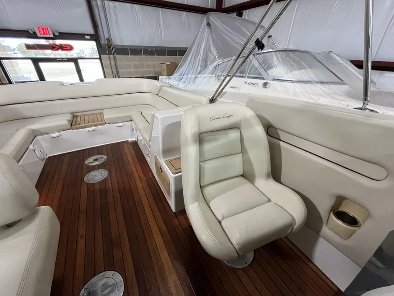 Slide: The Image of 2005 Chris-Craft Corsair 28 boat interior with white seating and wooden flooring. - 19
