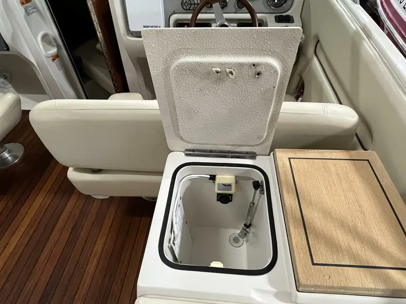 Slide: The Image of 2005 Chris-Craft Corsair 28 interior with open storage compartment and wooden flooring. - 22