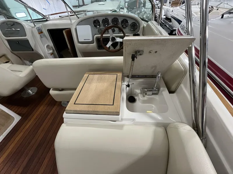 Slide: The Image of 2005 Chris-Craft Corsair 28 interior with steering wheel, dashboard, and sink area. - 23