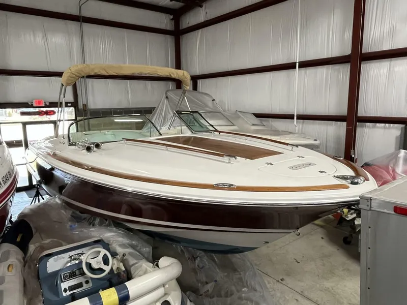 Slide: The Image of 2005 Chris-Craft Corsair 28 boat in storage, featuring classic design and wooden accents. - 3