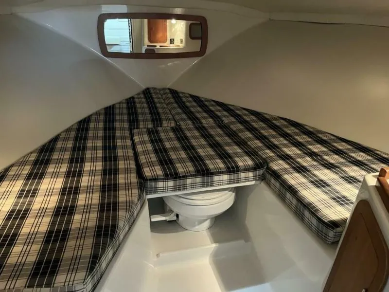 Slide: The Image of 2005 Chris-Craft Corsair 28 cabin interior with plaid cushions and compact toilet. - 32