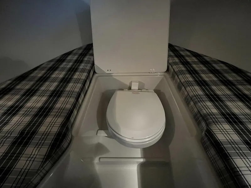 Slide: The Image of 2005 Chris-Craft Corsair 28 boat interior with plaid seating and compact toilet. - 36