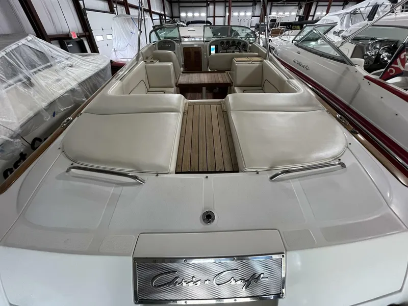 Slide: The Image of 2005 Chris-Craft Corsair 28 boat interior with beige seating and wooden deck. - 43