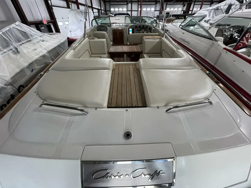 Slide: The Image of 2005 Chris-Craft Corsair 28 boat interior with beige seating and wooden deck. - 44