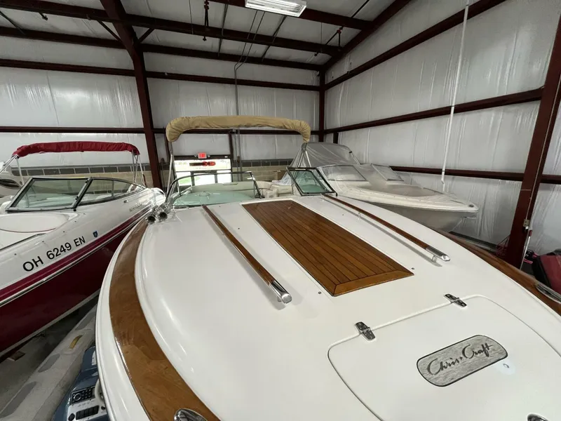 Slide: The Image of 2005 Chris-Craft Corsair 28 boat in storage, featuring sleek design and wooden accents. - 5