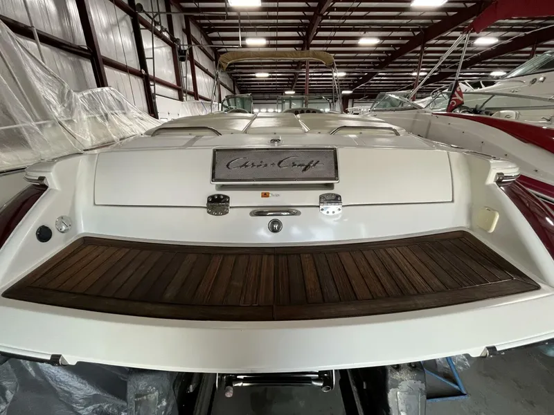 Slide: The Image of 2005 Chris-Craft Corsair 28 boat in storage, rear view with wooden deck. - 9