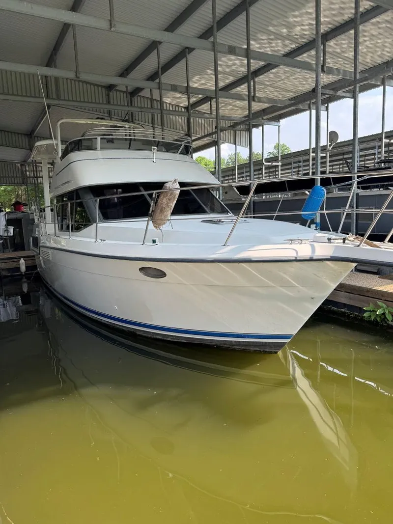 The Image of 1994 Carver 350 Aft Cabin yacht docked in a covered marina. - 1