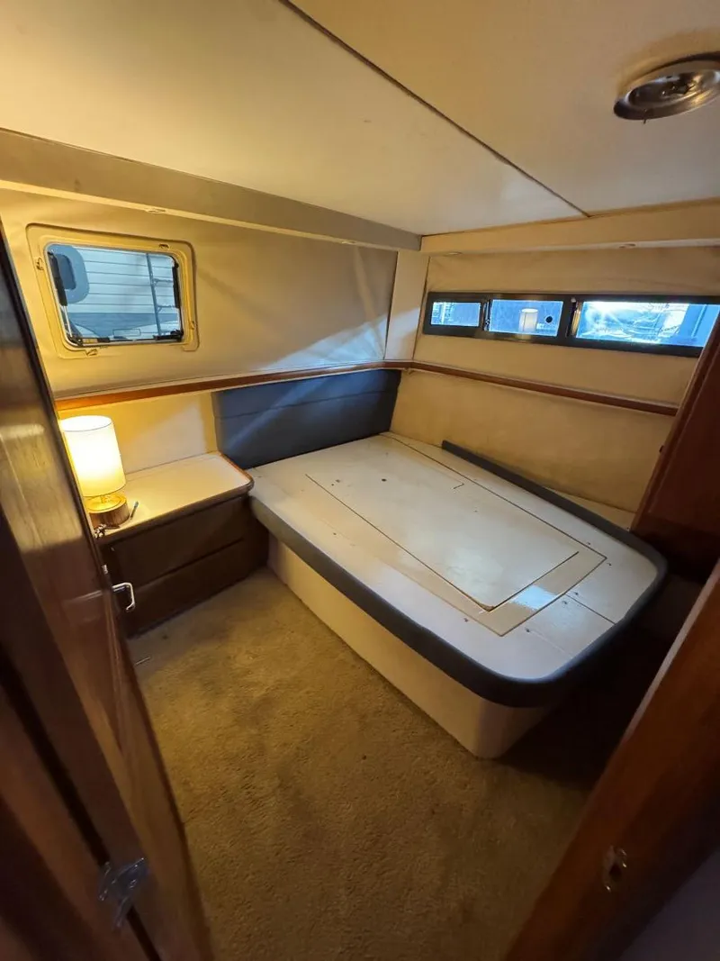 Slide: The Image of 1994 Carver 350 Aft Cabin interior with bed, windows, and lamp. - 27