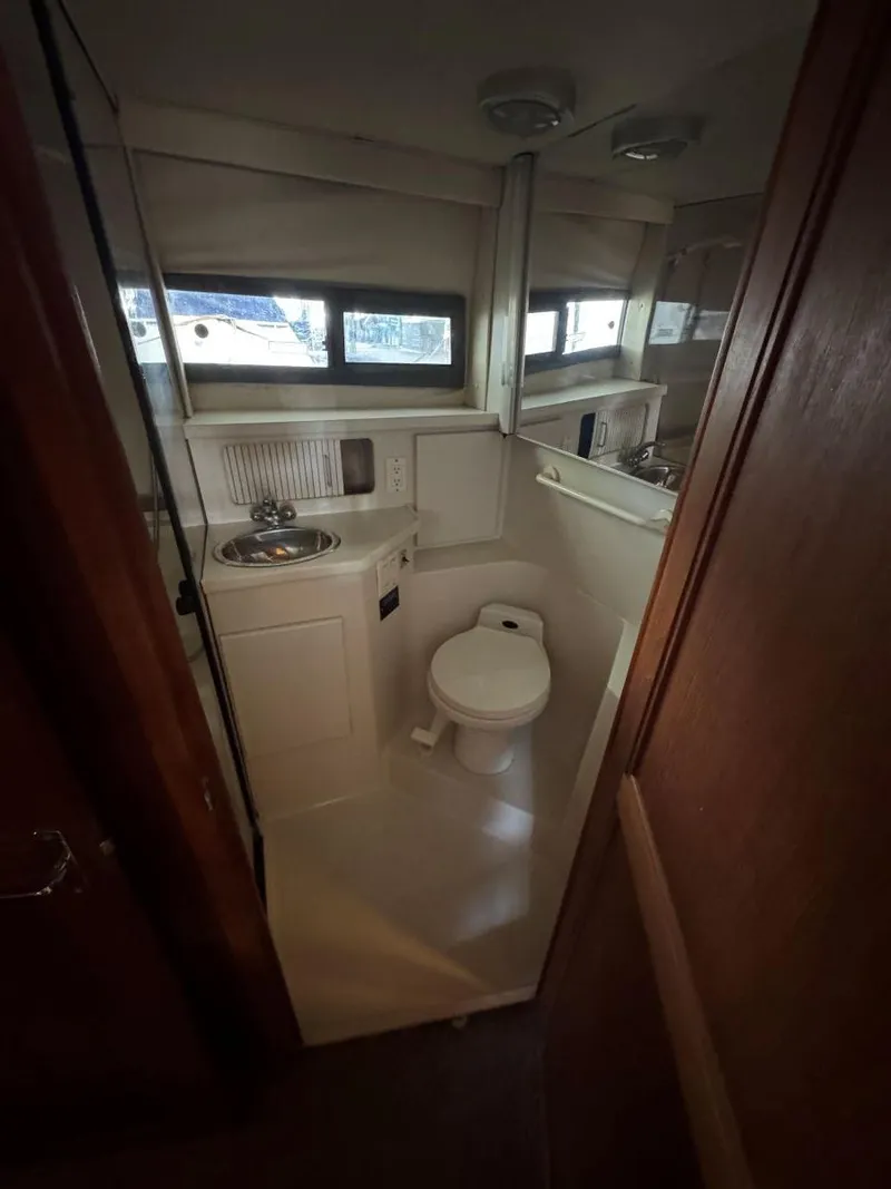 Slide: The Image of 1994 Carver 350 Aft Cabin bathroom with sink, toilet, and mirror. - 29