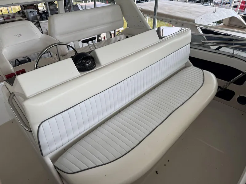 Slide: The Image of 1994 Carver 350 Aft Cabin boat interior with white seating and steering wheel. - 12