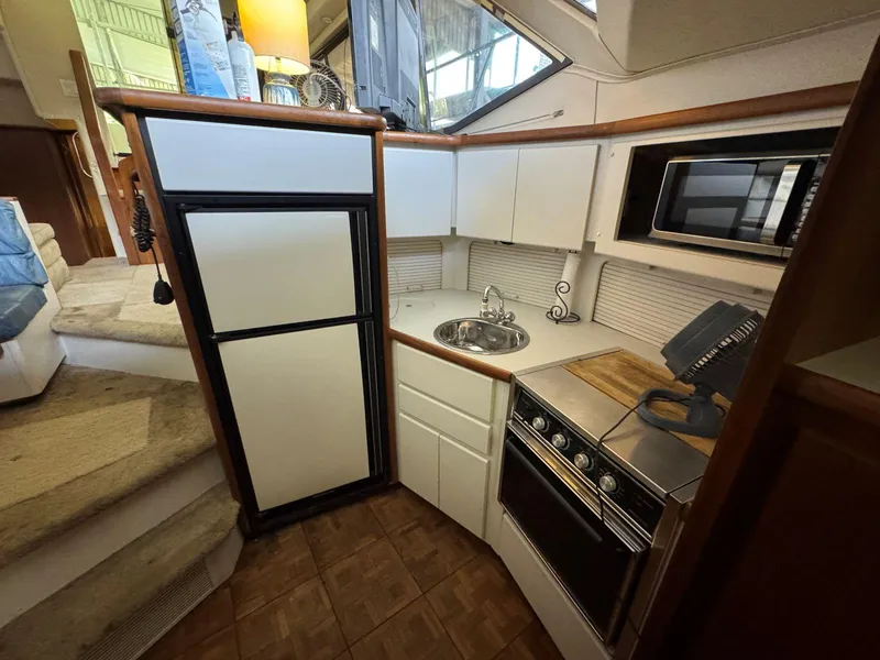 Slide: The Image of 1994 Carver 350 Aft Cabin kitchen with fridge, stove, and microwave. - 23