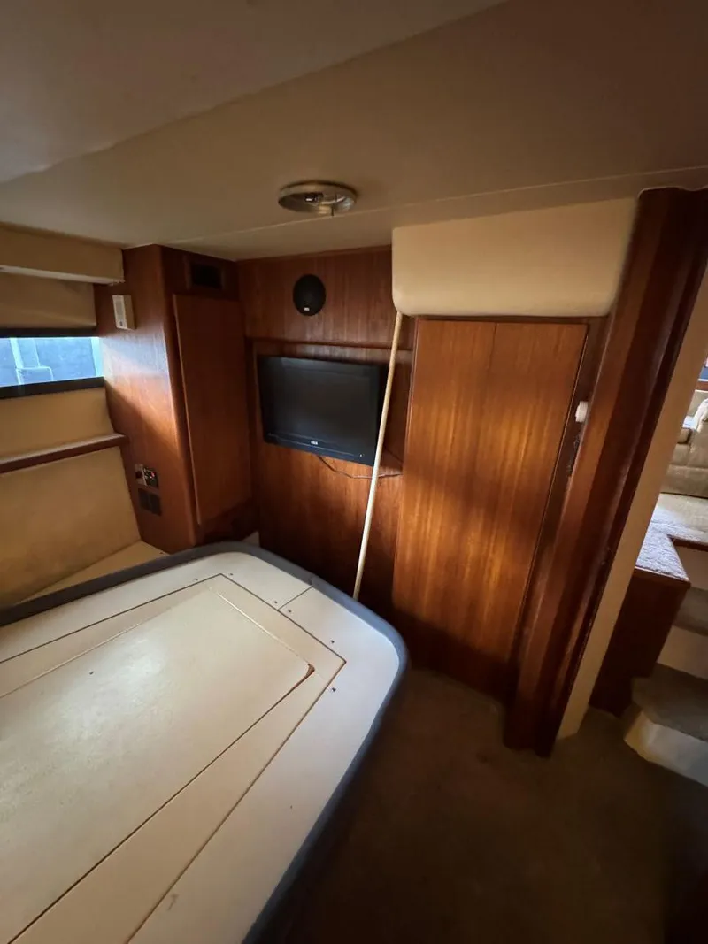 Slide: The Image of Interior of 1994 Carver 350 Aft Cabin with wood paneling and TV. - 28