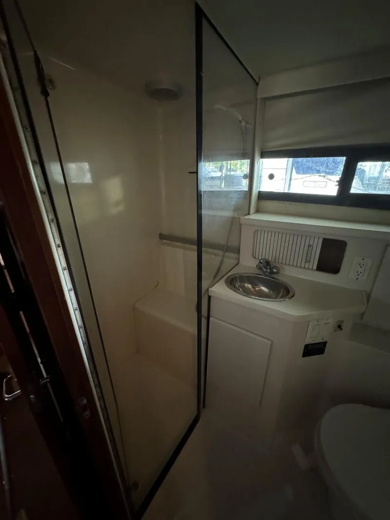 Slide: The Image of 1994 Carver 350 Aft Cabin bathroom with shower, sink, and window. - 30