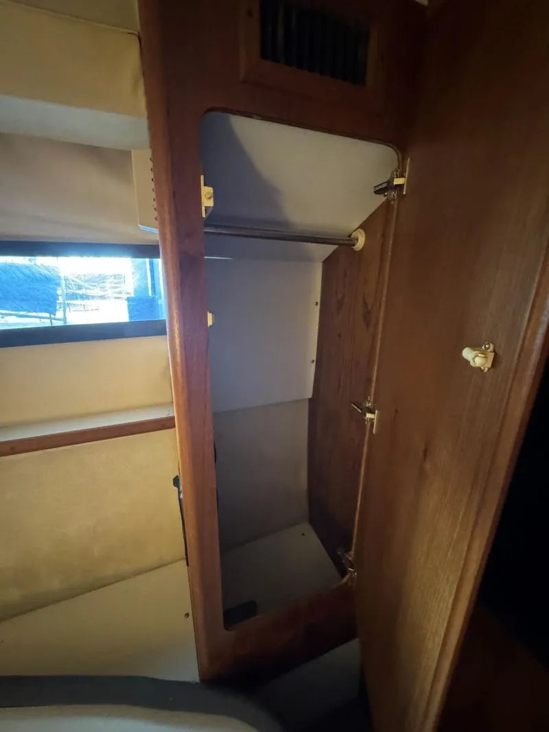 Slide: The Image of 1994 Carver 350 Aft Cabin interior closet with wooden finish and open door. - 32