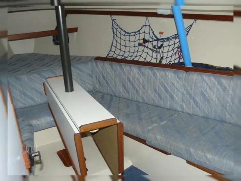 Slide: The Image of Interior of 1990 Catalina Capri 26 Wing Keel sailboat with blue seating and storage net. - 7