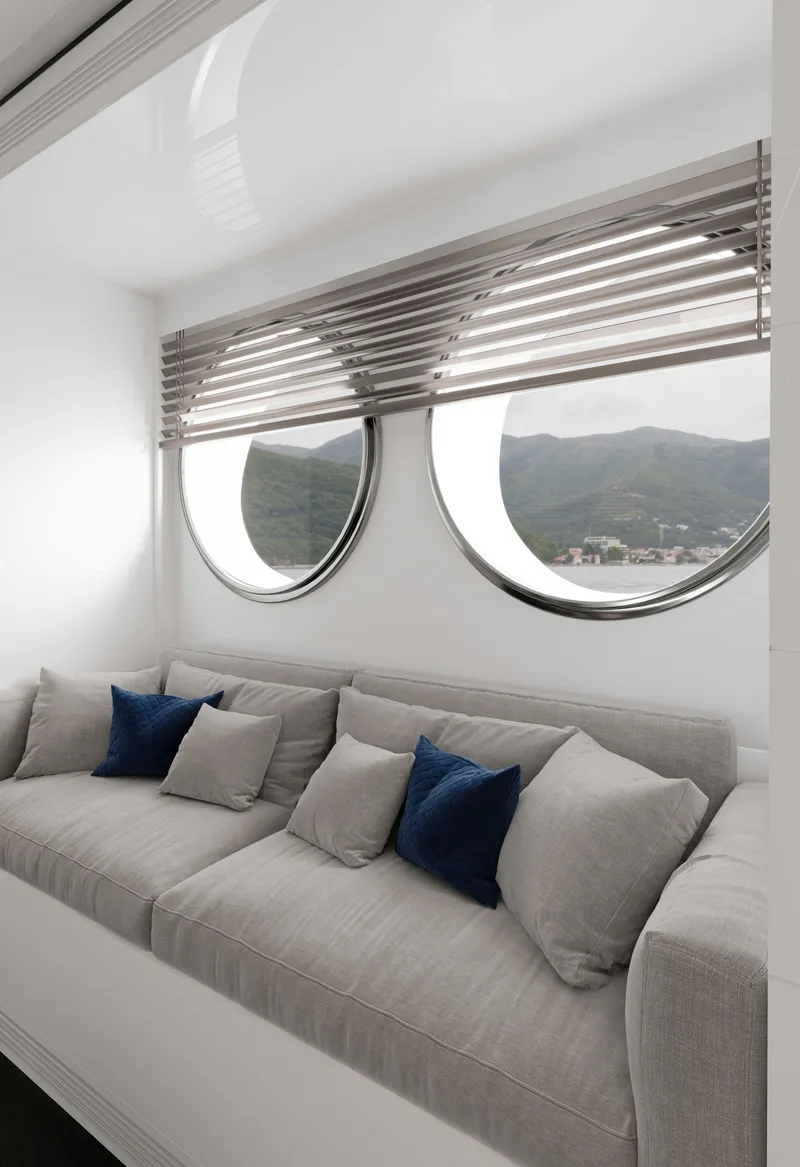 Slide: The Image of Luxurious yacht interior with round windows, gray sofa, and blue cushions, 2027 Tufan and Brothers Mako Shark. - 12