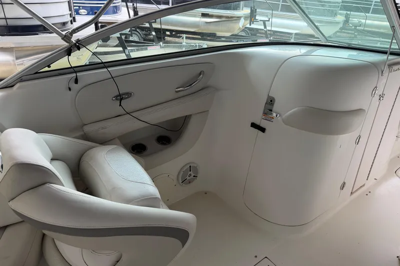 Slide: The Image of Interior of a 2006 Chaparral 260 SSi boat, featuring white seating and dashboard. - 9