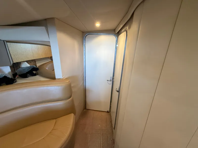 Slide: The Image of Interior of 1999 Formula 41 PC yacht, featuring beige seating and a closed door. - 19