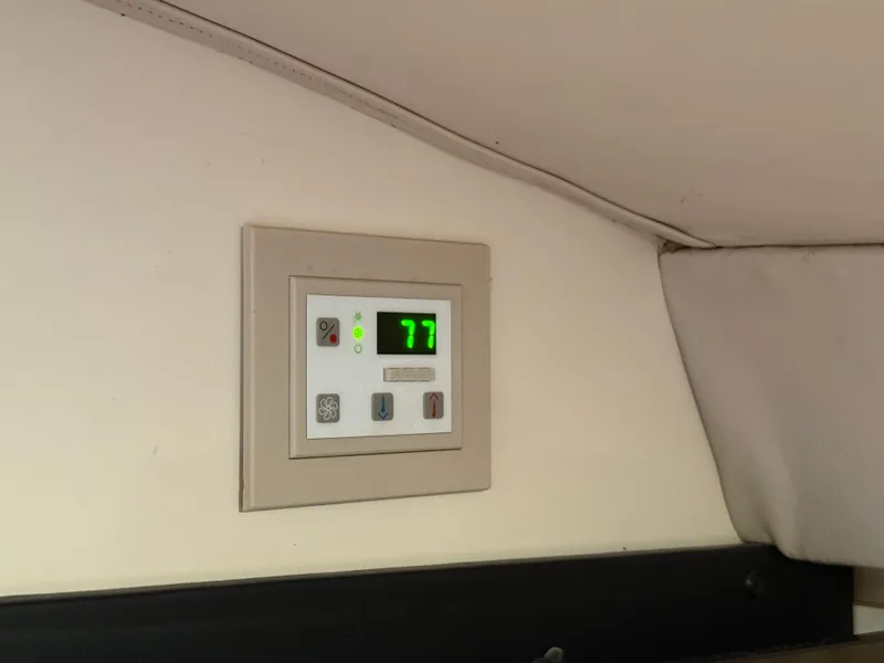 Slide: The Image of Control panel inside a 1999 Formula 41 PC boat, displaying temperature at 77 degrees. - 25