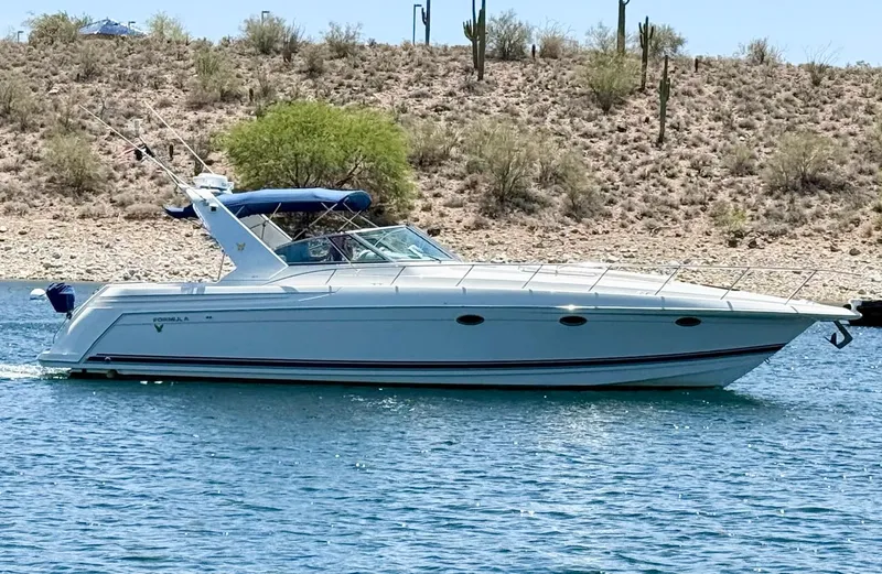 Slide: The Image of 1999 Formula 41 PC boat cruising on a lake with desert landscape background. - 32