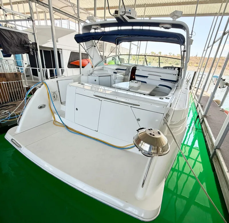 Slide: The Image of 1999 Formula 41 PC yacht docked, featuring spacious deck and seating area under canopy. - 33
