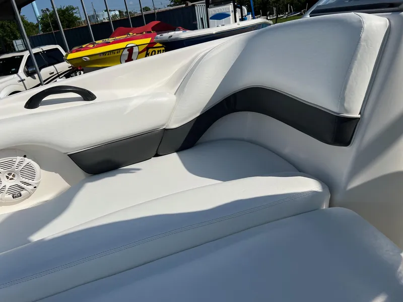 Slide: The Image of 2006 Yamaha SX210 boat interior with white and black seating, featuring a speaker and handle. - 4