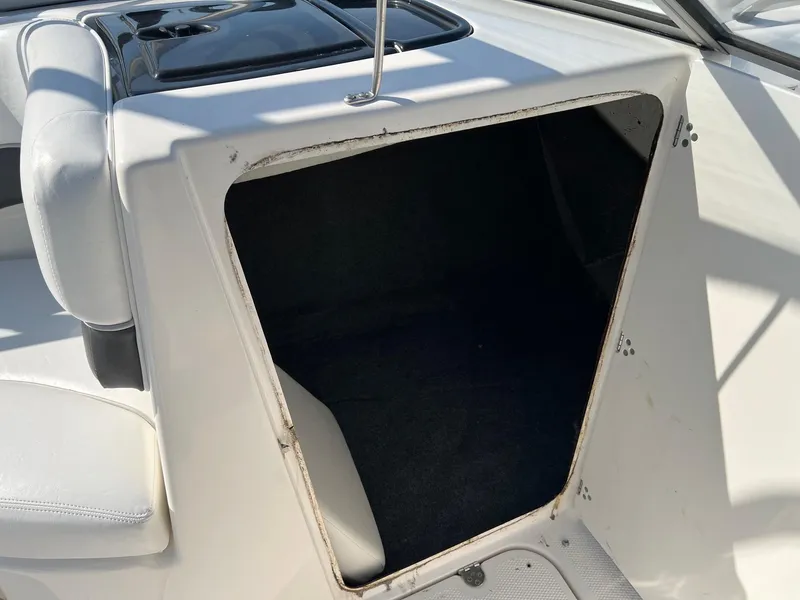 Slide: The Image of 2006 Yamaha SX210 boat storage compartment with open hatch, white interior. - 8