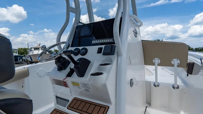 Slide: The Image of 2020 Tidewater 232 LXF boat console with steering wheel and controls under a blue sky. - 12