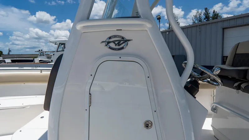 Slide: The Image of 2020 Tidewater 232 LXF boat console with steering wheel, under a clear blue sky. - 15