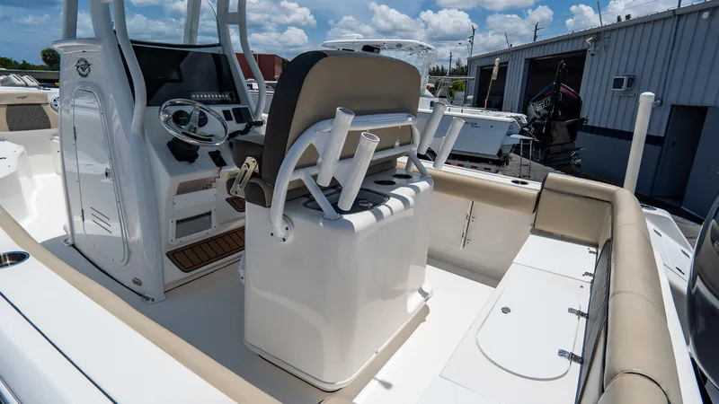 Slide: The Image of 2020 Tidewater 232 LXF boat interior with helm, seating, and storage under a sunny sky. - 7