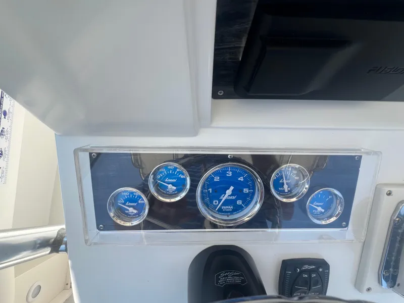 Slide: The Image of Dashboard of a 2003 Shamrock 220 Cuddy boat with blue gauges and controls. - 10