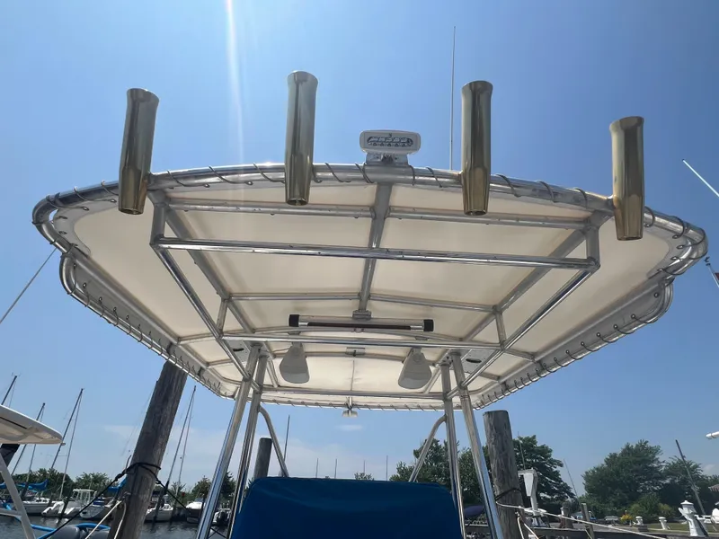 Slide: The Image of T-top of a 2003 Shamrock 220 Cuddy boat with rod holders, under clear sky. - 14