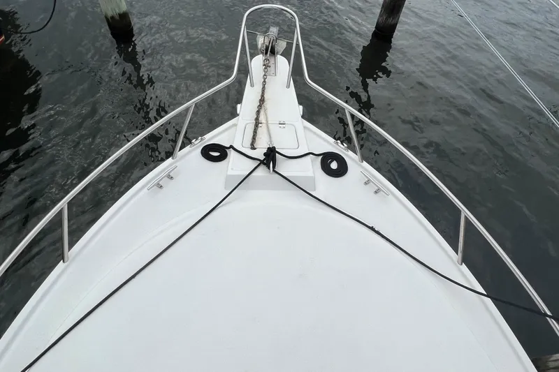 Slide: The Image of Bow view of 2003 Shamrock 220 Cuddy boat docked on calm water. - 16