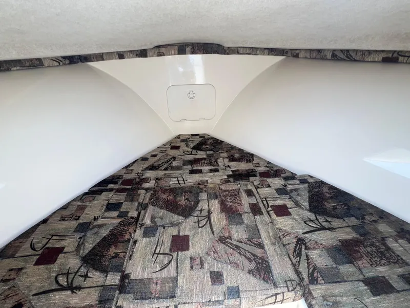 Slide: The Image of 2003 Shamrock 220 Cuddy cabin interior with patterned cushions and white walls. - 17