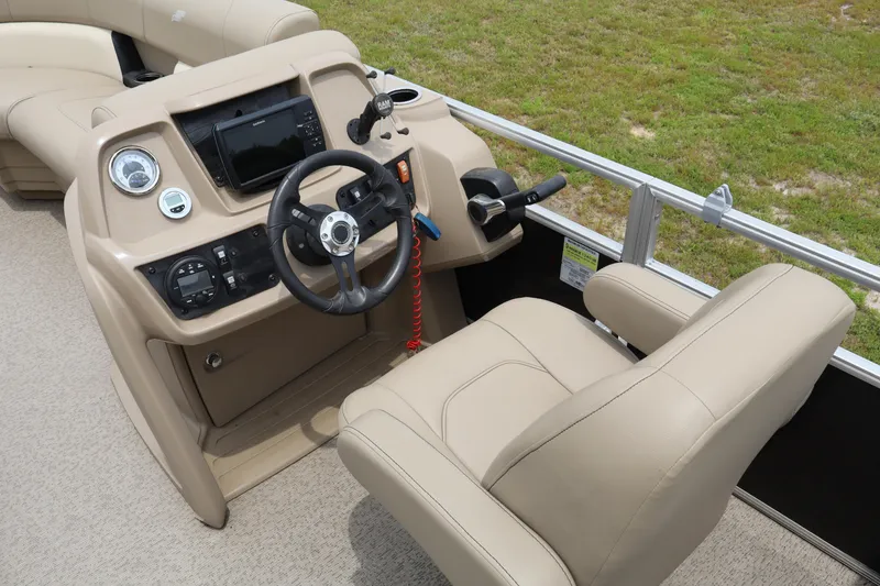 Slide: The Image of 2021 Starcraft LX 22 R boat interior with steering console and beige seating. - 12